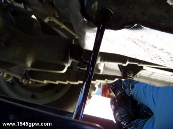 Let the oil drain into the pan. While this is draining, I will head over to the oil fitter and prepare to remove it.