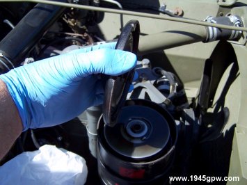 The oil filter lid will most likely have some oil on it. I will let it drip for a bit before moving it over to a towel for cleaning.